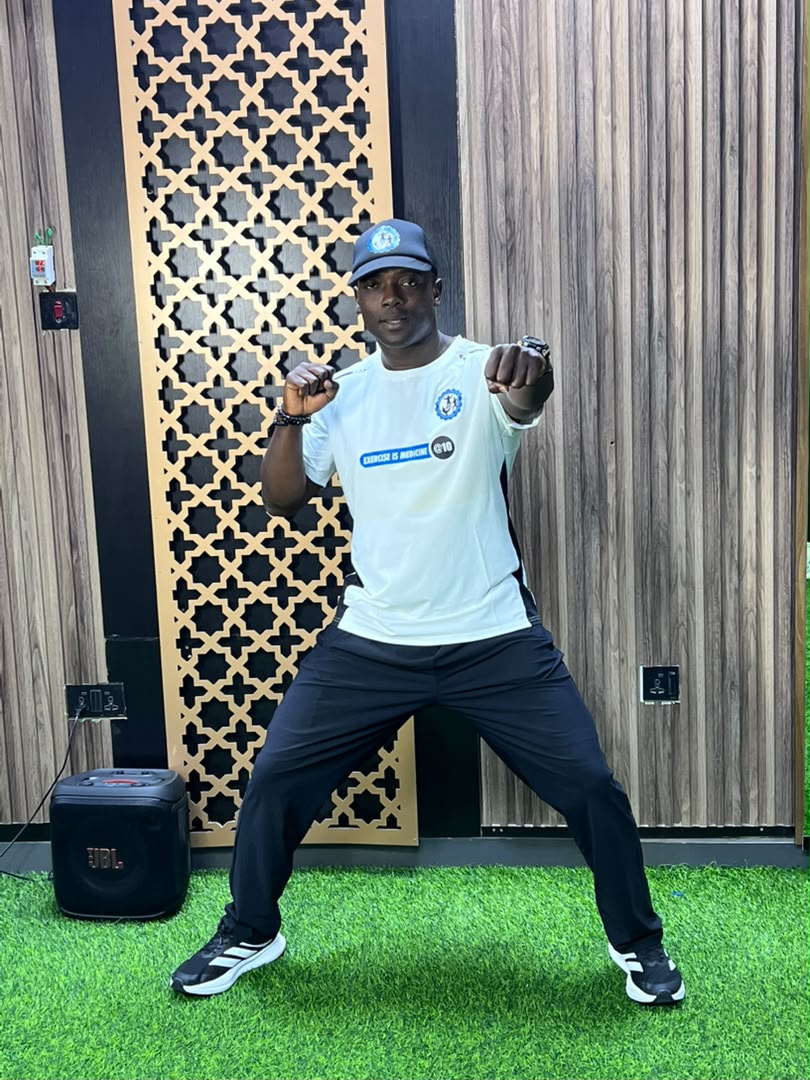 Coach Korede demonstrating a seated mobility stretch