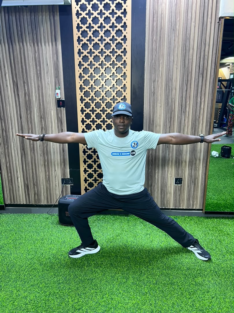 Coach Korede leading a lower-body mobility exercise