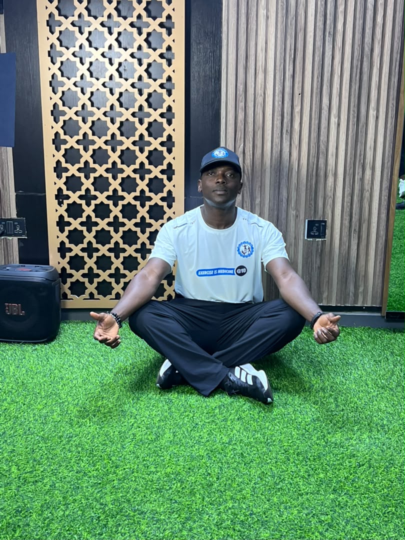 Coach Korede demonstrating a fitness movement indoors
