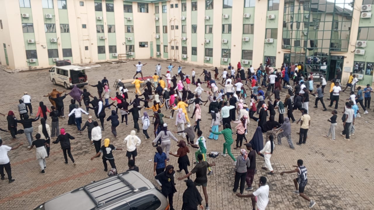 A large community aerobics session in an open courtyard
