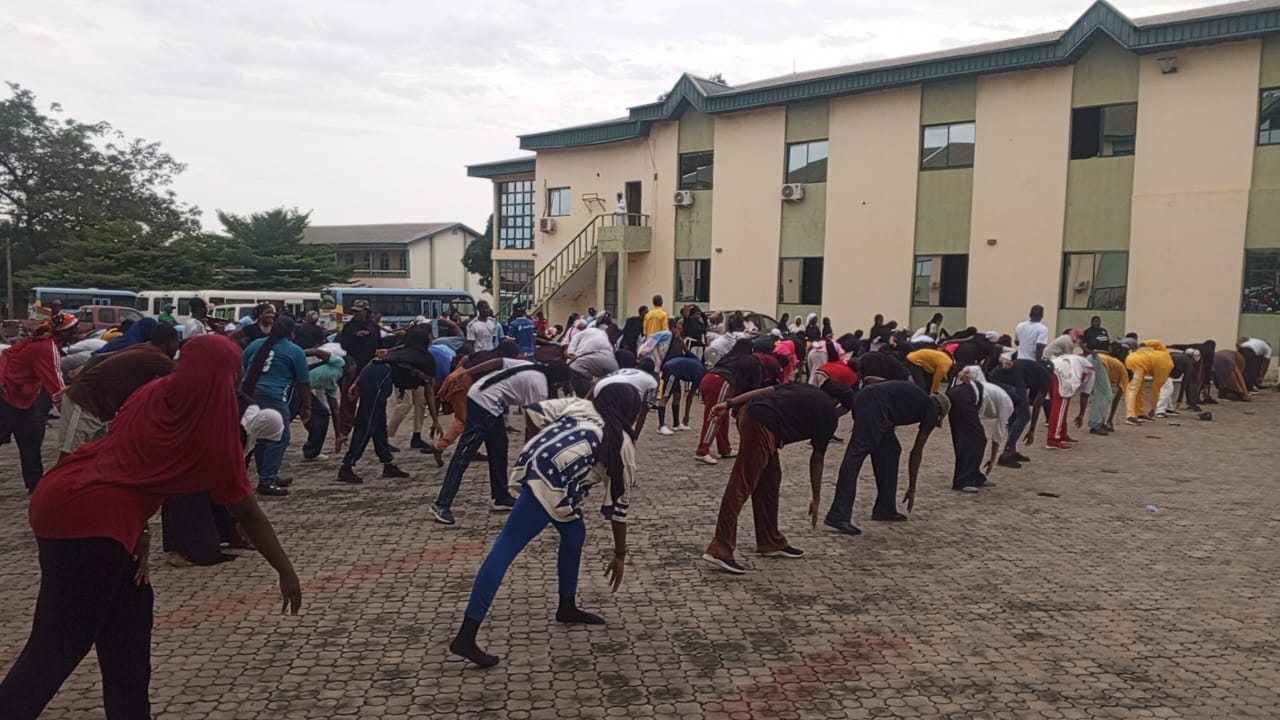 Community participants performing forward stretches outdoors