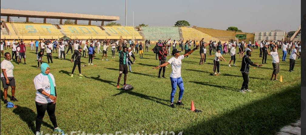A wide view of participants exercising on a stadium field